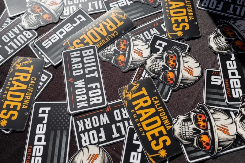 A pile of Trades Energy stickers on a table.